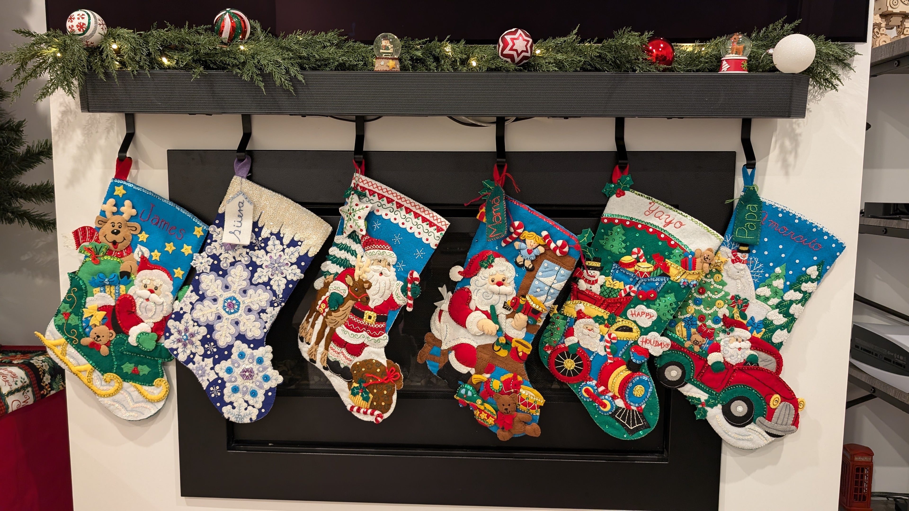 Colorful Christmas stockings hanging on a fireplace mantle.