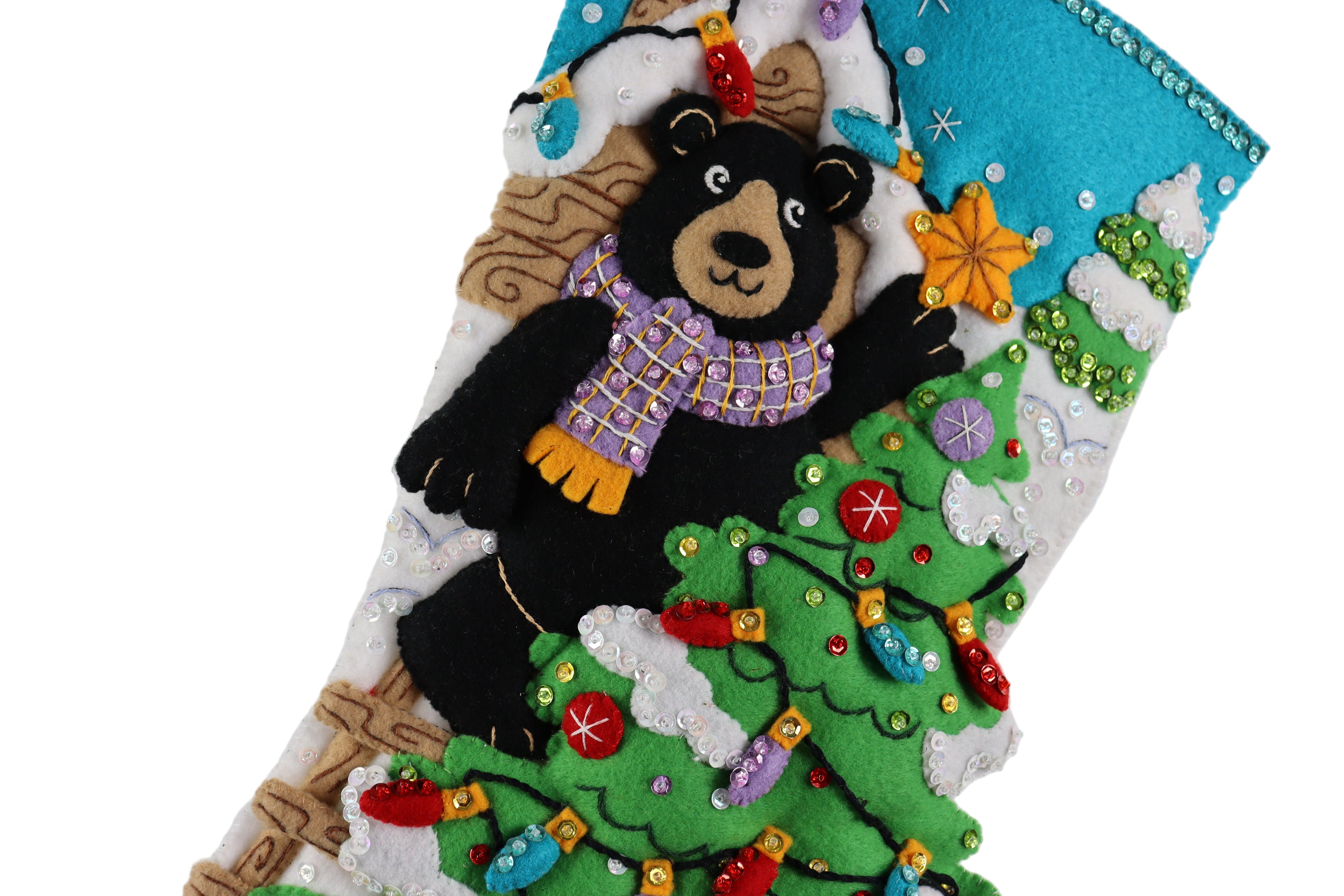 Decorative Christmas stocking with a bear on a tree, surrounded by colorful decorations.