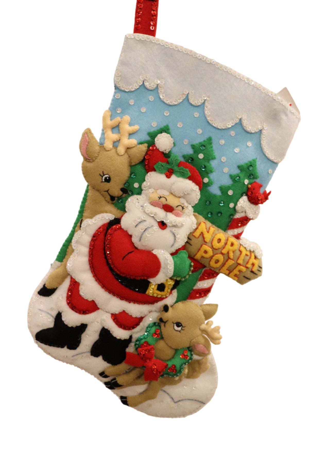 Finished North Pole Santa Bucilla felt Christmas stocking: Santa hugging the North Pole sign with two reindeer, a cardinal and snowy pine trees