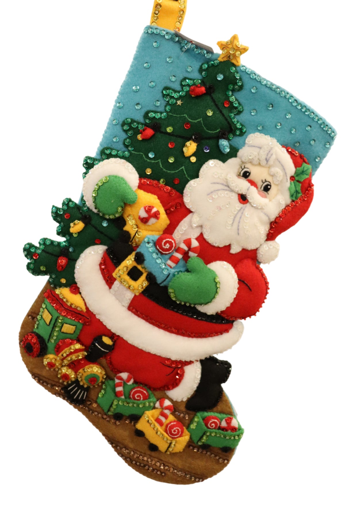 Finished Toy Train Santa Bucilla felt Christmas stocking: Santa carrying a Christmas tree and toys in front of a lit tree, with a toy train full of candy along the bottom